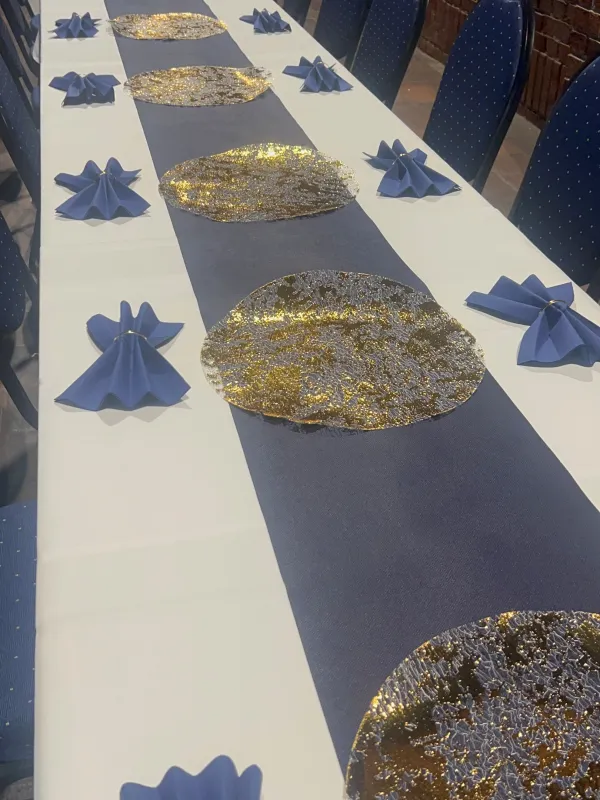 Goldene Platzteller und Navy-Servietten auf der Festtafel
